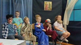 Scena z przedstawienia-pięcioro uczniów siedzi na krzesłach, bada ich chłopiec grający lekarza.