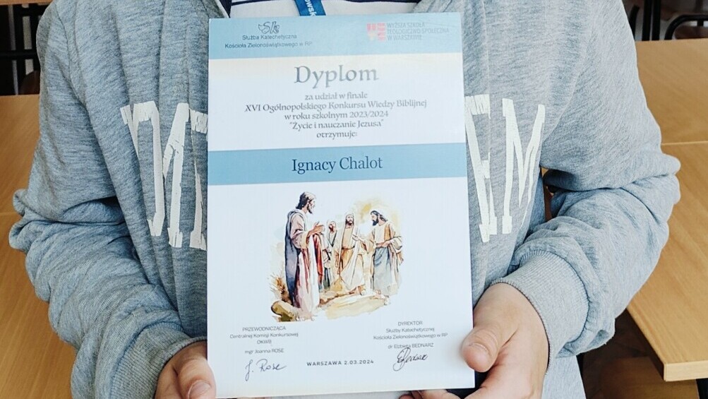 Ignacy Chalot trzyma w rękach dyplom.